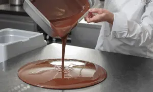 Un chef verse du chocolat fondu. Mycryo, c'est quoi ? C'est la magie du chocolat qui prend forme.