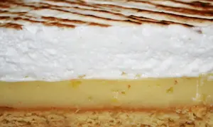 Tranche de tarte au citron avec une généreuse couche de meringue italienne dorée.