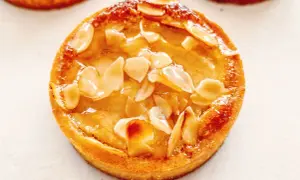 Tarte poire amandine dorée, garnie d'amandes effilées et d'un glaçage brillant. Un délice croustillant et fruité.