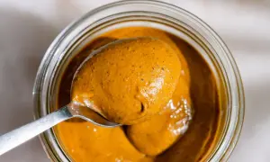 Une cuillère déborde de beurre de pistache onctueux, prêt à être dégusté. Une recette maison facile à réaliser.