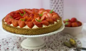 Tarte aux fraises sablé breton, garnie de crème pâtissière et de fraises fraîches, décorée de feuilles de menthe.