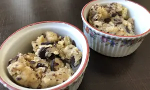 Deux ramequins remplis de pâte à cookie aux pépites de chocolat, prêts à être dégustés.