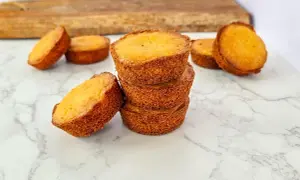 Pile de palets bretons dorés sur un marbre blanc, certains posés à côté.
