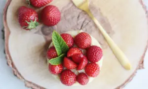 Délicieuse tarte aux fraises sans cuisson, garnie de fruits rouges frais et d'une touche de menthe. Un régal visuel et gustatif.