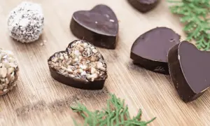 Chocolats maison en forme de cœur, certains garnis de noix, parfaits pour une recette petit chocolat maison facile.