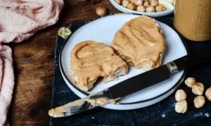 Tranches de pain généreusement tartinées d'une onctueuse pâte à tartiner chocolat blanc noisette, prêtes à être dégustées.