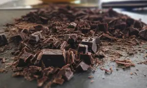 Mélange de morceaux et de copeaux de chocolat noir, prêt pour apprendre comment faire fondre du chocolat.