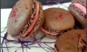 Macarons au chocolat avec ganache framboise et une touche de gélatine pour la brillance.