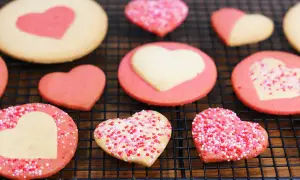 Délicieux cookies maison en forme de cœur, certains décorés de vermicelles colorés. Parfait pour apprendre comment faire des cookies maison.