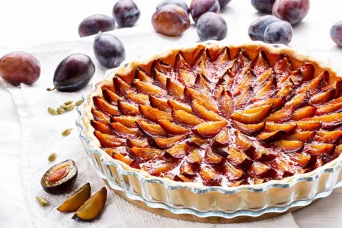 Tarte aux quetsches allemande, une pâtisserie gourmande aux prunes juteuses disposées en rosace sur une pâte dorée.