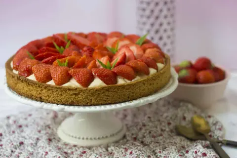 Tarte aux fraises sablé breton, garnie de crème pâtissière et de fraises fraîches, décorée de feuilles de menthe.