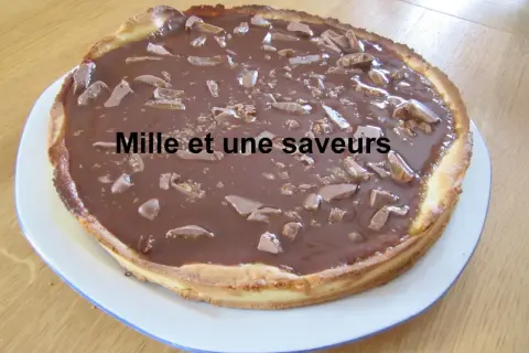 Une délicieuse tarte aux daims, recouverte d'un glaçage au chocolat et parsemée de morceaux de caramel croquant. Un vrai régal pour les gourmands !