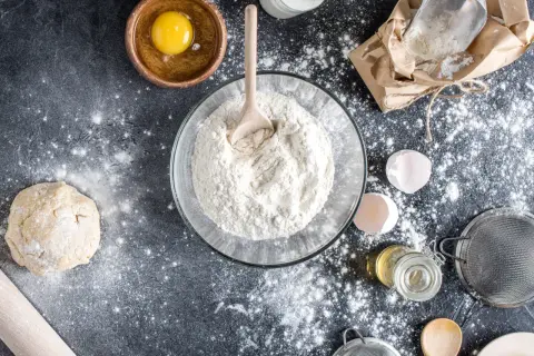 Préparation d'une recette avec de la farine T80, c'est quoi ? Œuf, pâte, lait, huile, tamis, tout est prêt pour le pain.