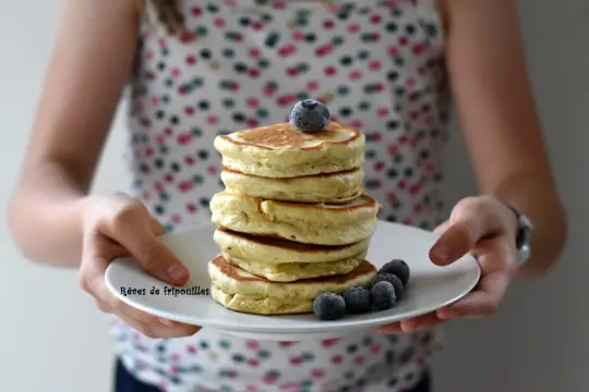 Pile de pancakes moelleux, parfaits pour une recette pancakes rapide. Garnis de myrtilles fraîches, ils invitent à la gourmandise.