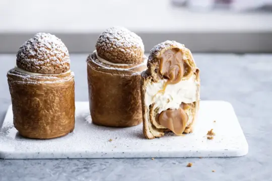 Trois pâtisseries gourmandes, inspirées d'une recette Saint Honoré, garnies de crème et de caramel coulant.