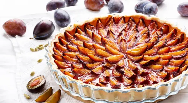 Tarte aux quetsches allemande, une pâtisserie gourmande aux prunes juteuses disposées en rosace sur une pâte dorée.