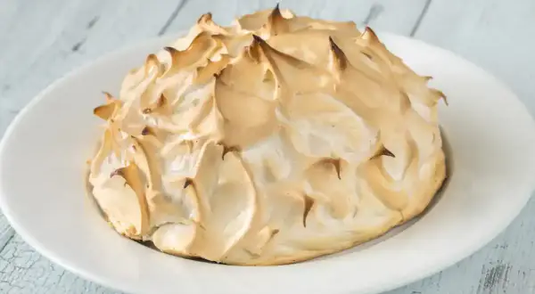 Meringue dorée et aérienne, prête à être servie sur une omelette norvégienne. Un délice visuel et gustatif.