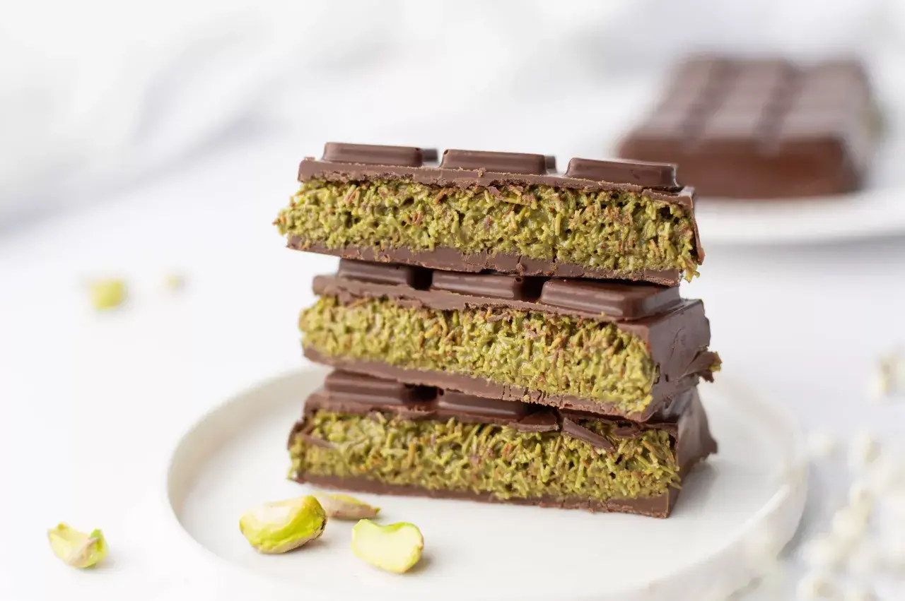 Chocolats fourrés aux pistaches, une recette gourmande inspirée de Dubaï. Des carrés de chocolat noir renfermant une garniture verte et croquante.