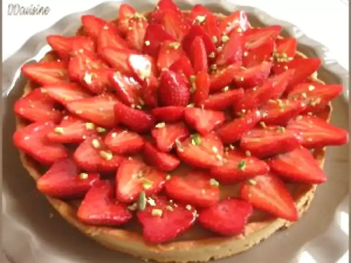 Tarte aux fraises fraîchement préparée, garnie de fraises coupées et de pistaches concassées. Un délice visuel et gustatif.