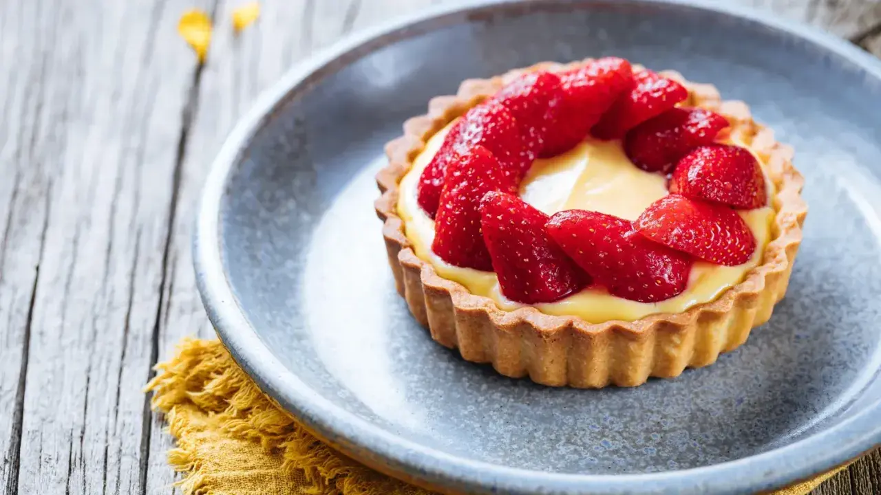 Tarte aux fraises sur pâte brisée, garnie d'une crème pâtissière onctueuse et de fraises fraîches. Un délice !