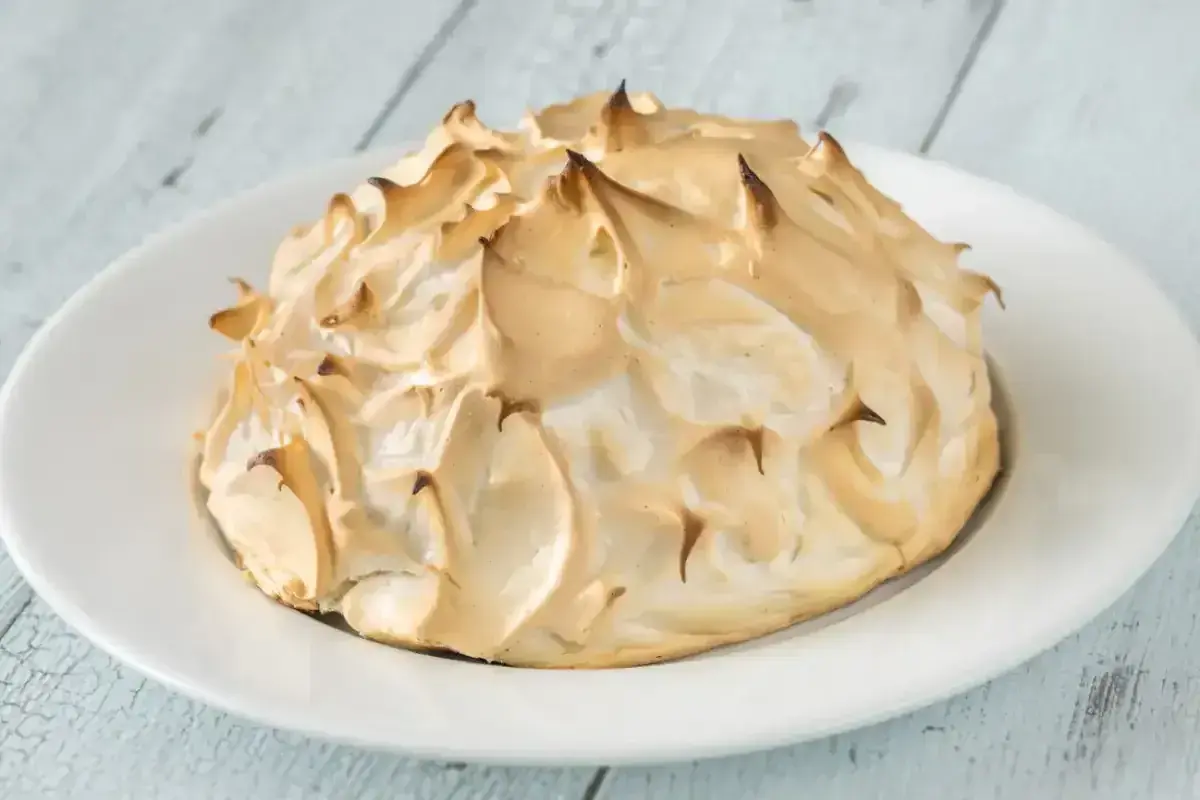Meringue dorée et aérienne, prête à être servie sur une omelette norvégienne. Un délice visuel et gustatif.