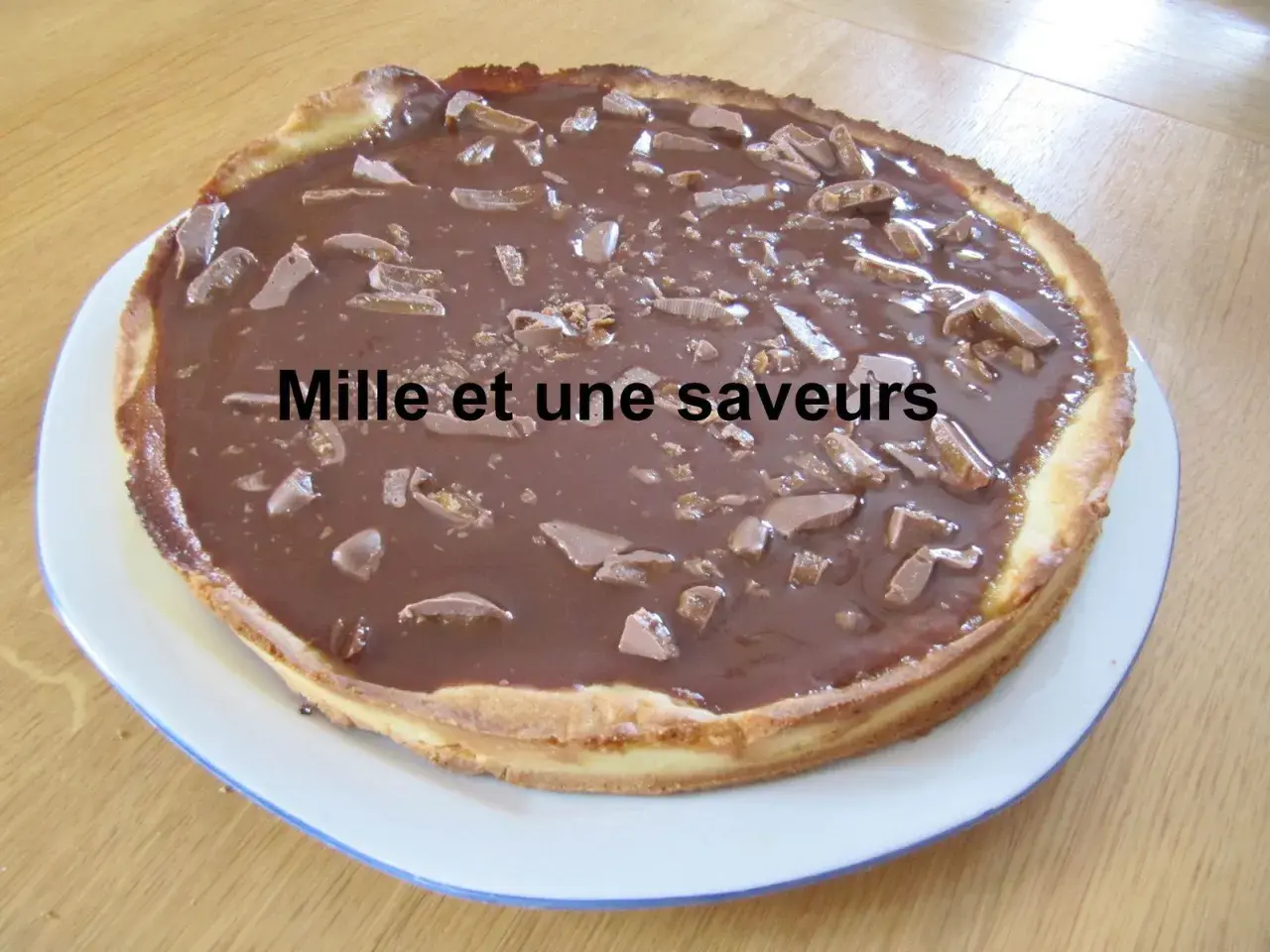 Une délicieuse tarte aux daims, recouverte d'un glaçage au chocolat et parsemée de morceaux de caramel croquant. Un vrai régal pour les gourmands !