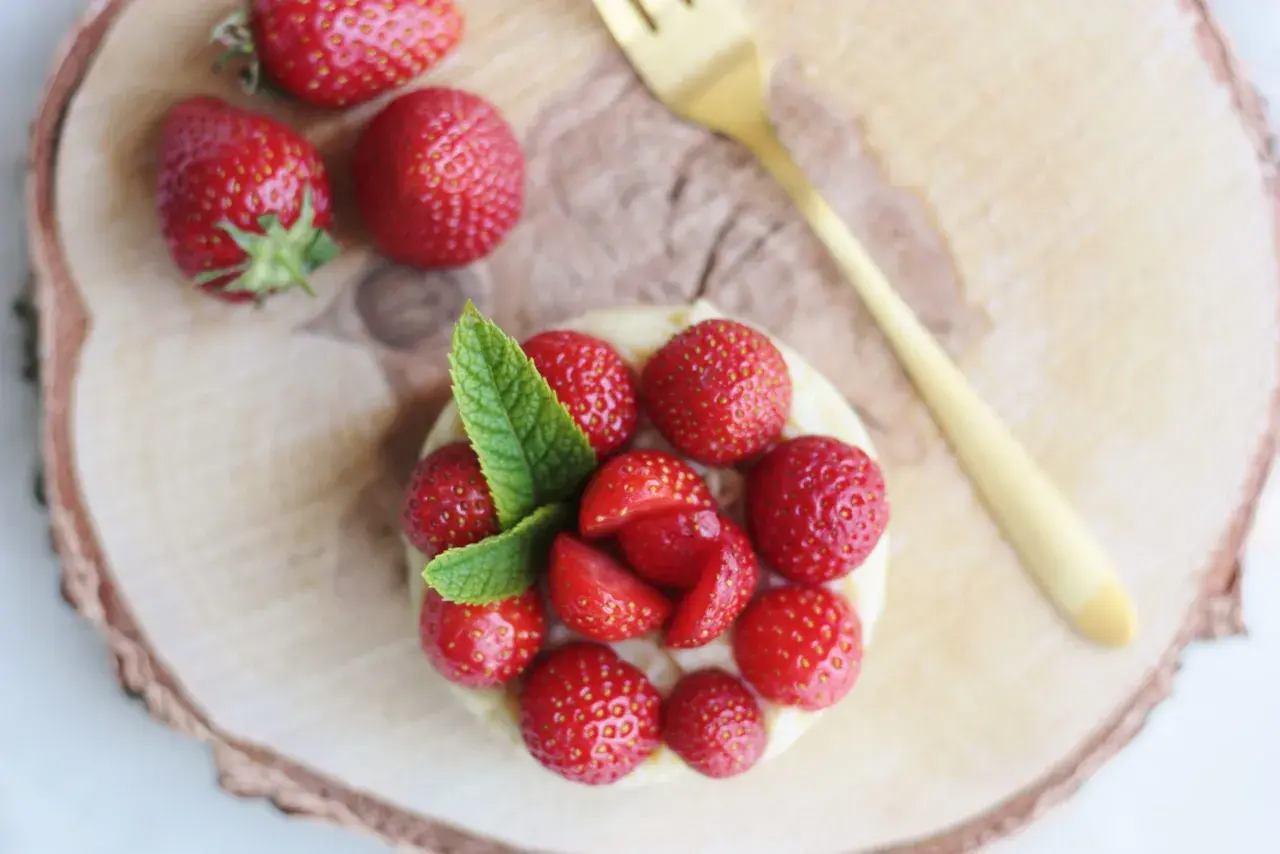 Délicieuse tarte aux fraises sans cuisson, garnie de fruits rouges frais et d'une touche de menthe. Un régal visuel et gustatif.