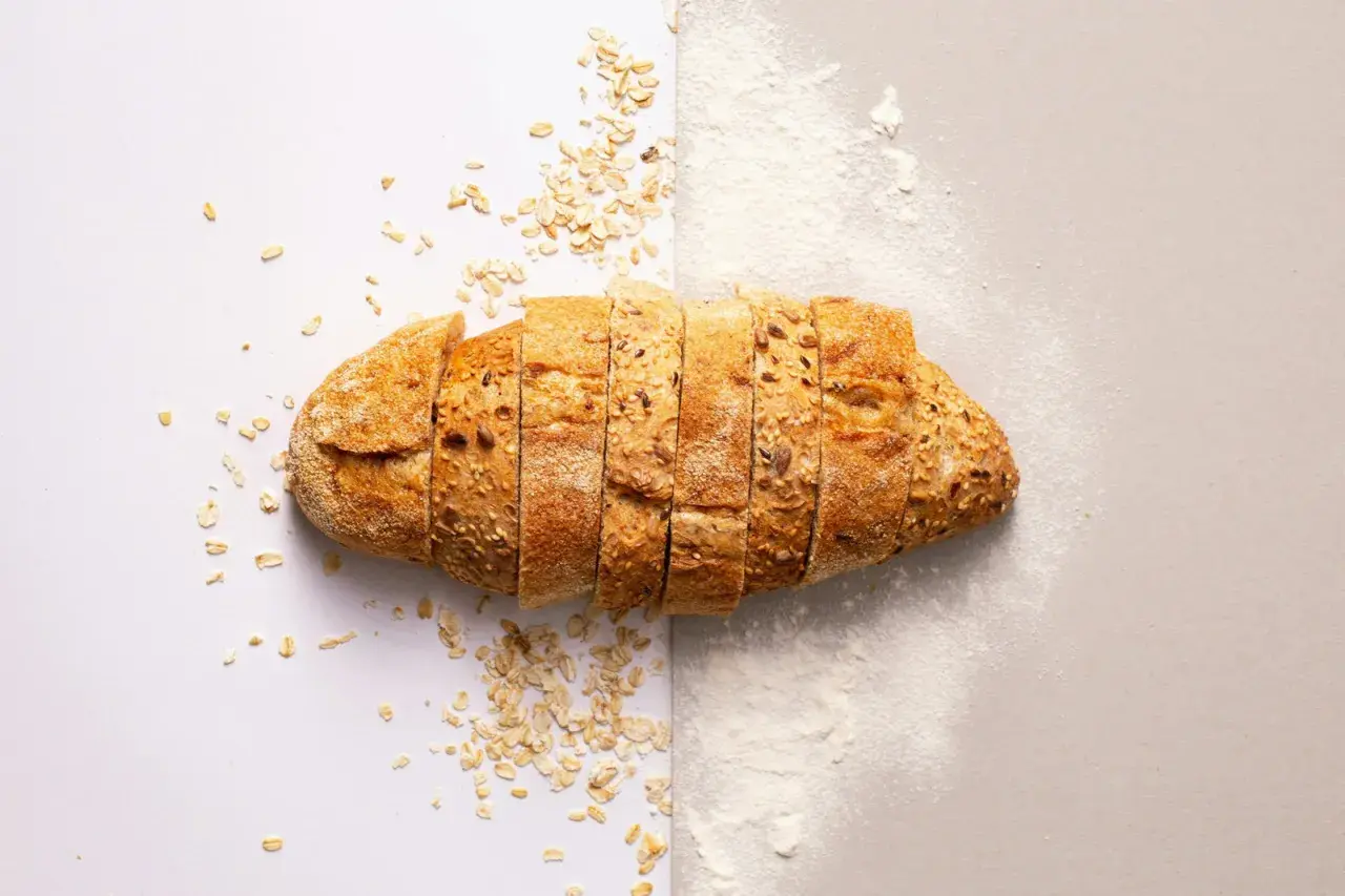Pain de campagne tranché, parsemé de flocons d'avoine et de farine. Une idée pour par quoi remplacer la farine de seigle.