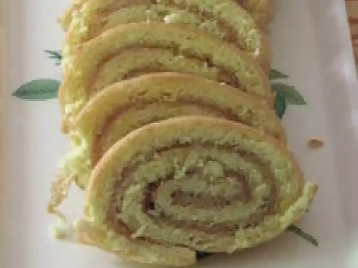 Roulé à la confiture, prêt à être recouvert d'une pâte d'amande pour une recette de gâteau gourmande.