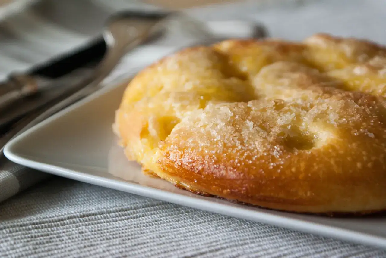 Tarte au sucre dor&eacute;e et croustillante, un d&eacute;lice de la recette de tarte au sucre de grand-m&egrave;re, servie sur une assiette blanche.