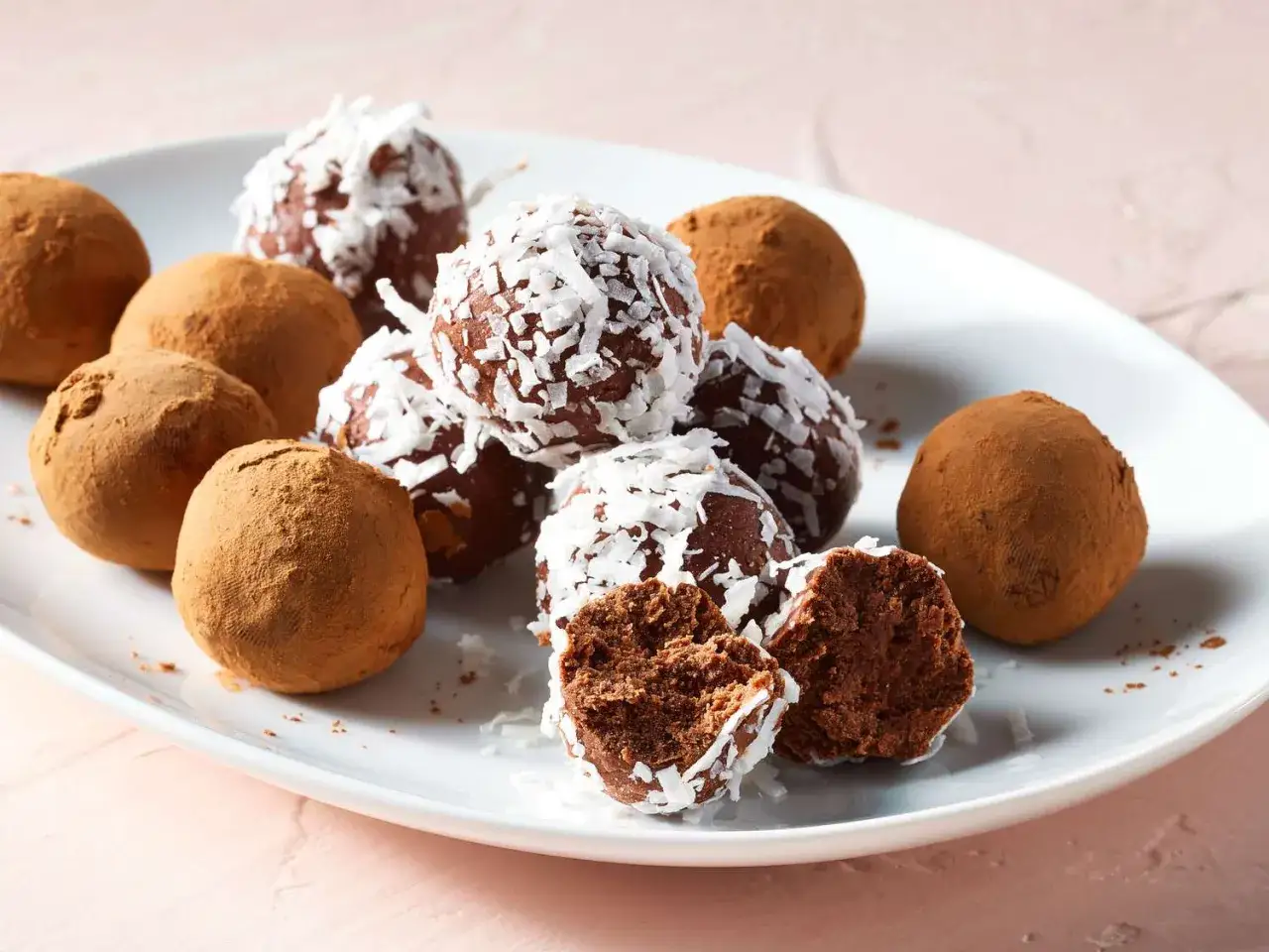 Assortiment de truffes au chocolat, certaines enrobées de cacao, d'autres de noix de coco râpée. Parfaites pour une recette des truffes au chocolat facile et gourmande.