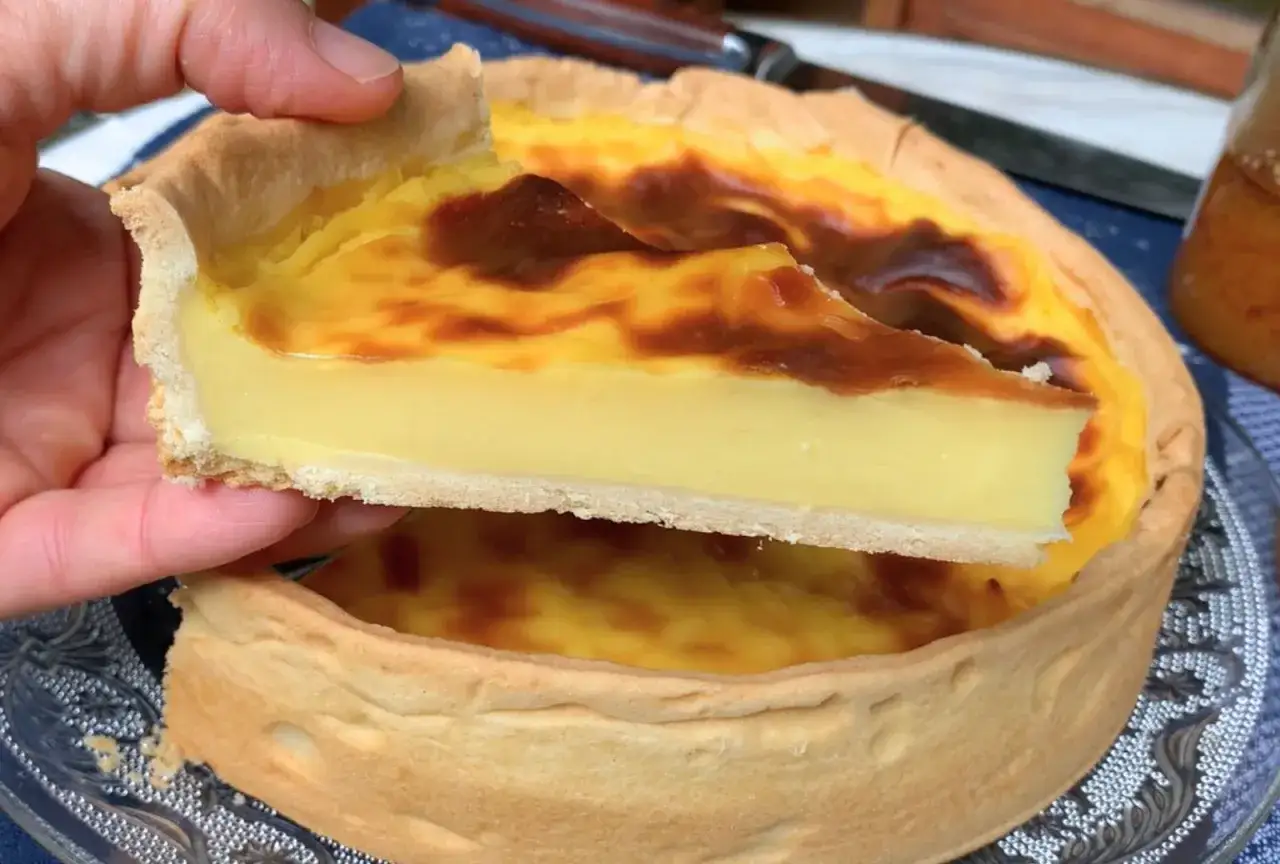 Une part de flan onctueux sur sa pâte brisée dorée. Un délice fait maison, prêt à être dégusté.