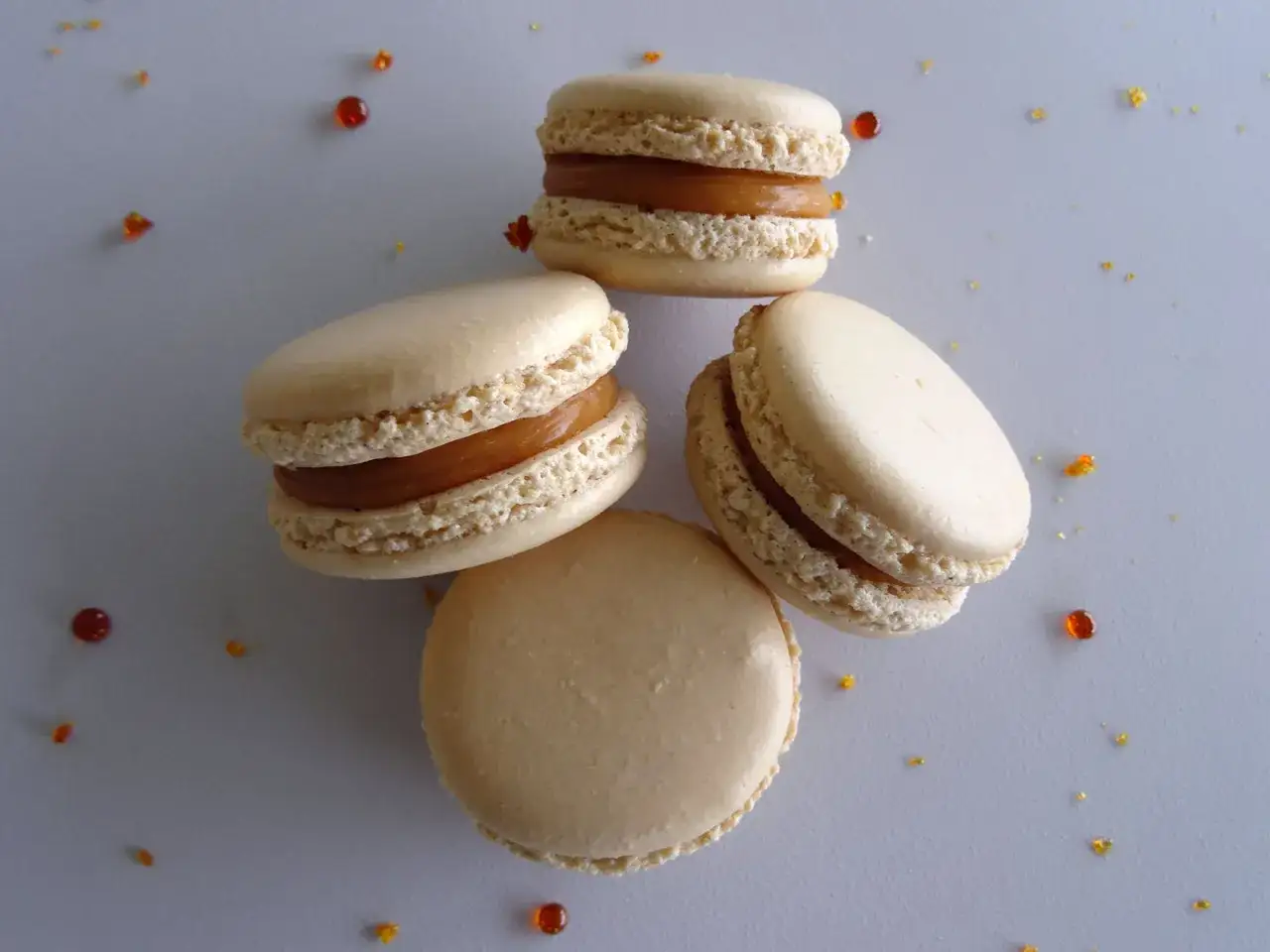 Quatre macarons à la ganache caramel beurre salé, parsemés de quelques éclats de caramel.