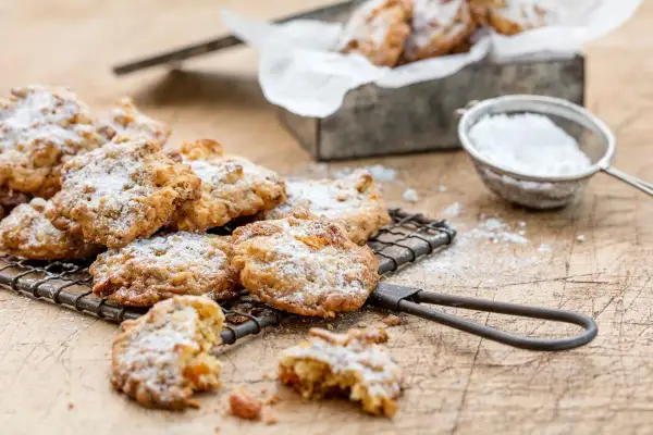 Délicieux cookies aux fruits secs, saupoudrés de sucre glace, sur une grille de refroidissement.