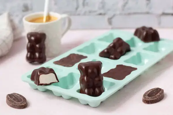 Délicieux oursons en guimauve recette, enrobés de chocolat noir, prêts à être dégustés. Une gourmandise maison.