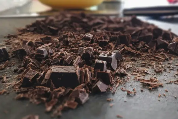 Mélange de morceaux et de copeaux de chocolat noir, prêt pour apprendre comment faire fondre du chocolat.