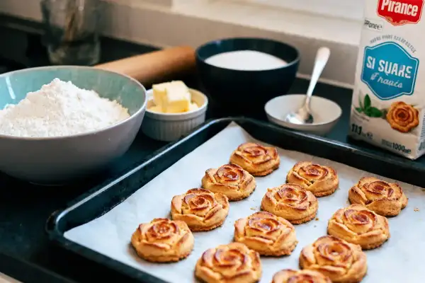 Délicieux biscuits en forme de rose des sables dorés sur une plaque de cuisson, prêts à être dégustés.